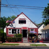 This is an image of a Baychester House With American and Puerto Rican Flags