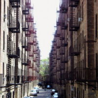 This is an image of Pelham Parkway Parking Alley Between Apartment Buildings