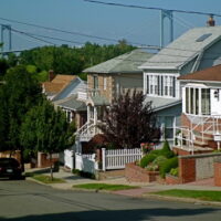 This is an image of Whitestone Houses With Bronx-Whitestone Bridge in the Background